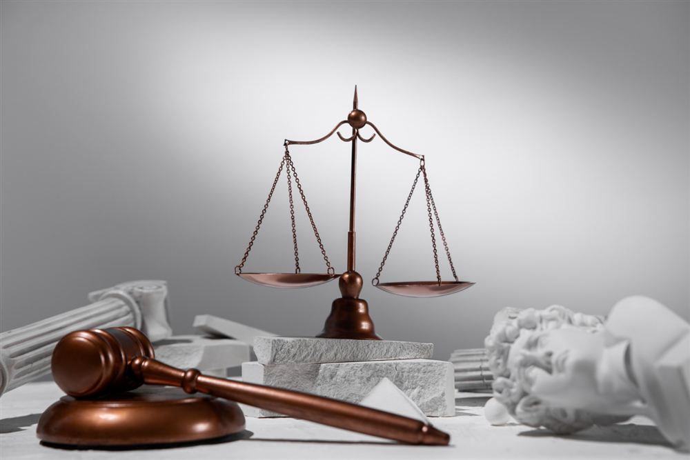 Scales of justice and a gavel on a white table