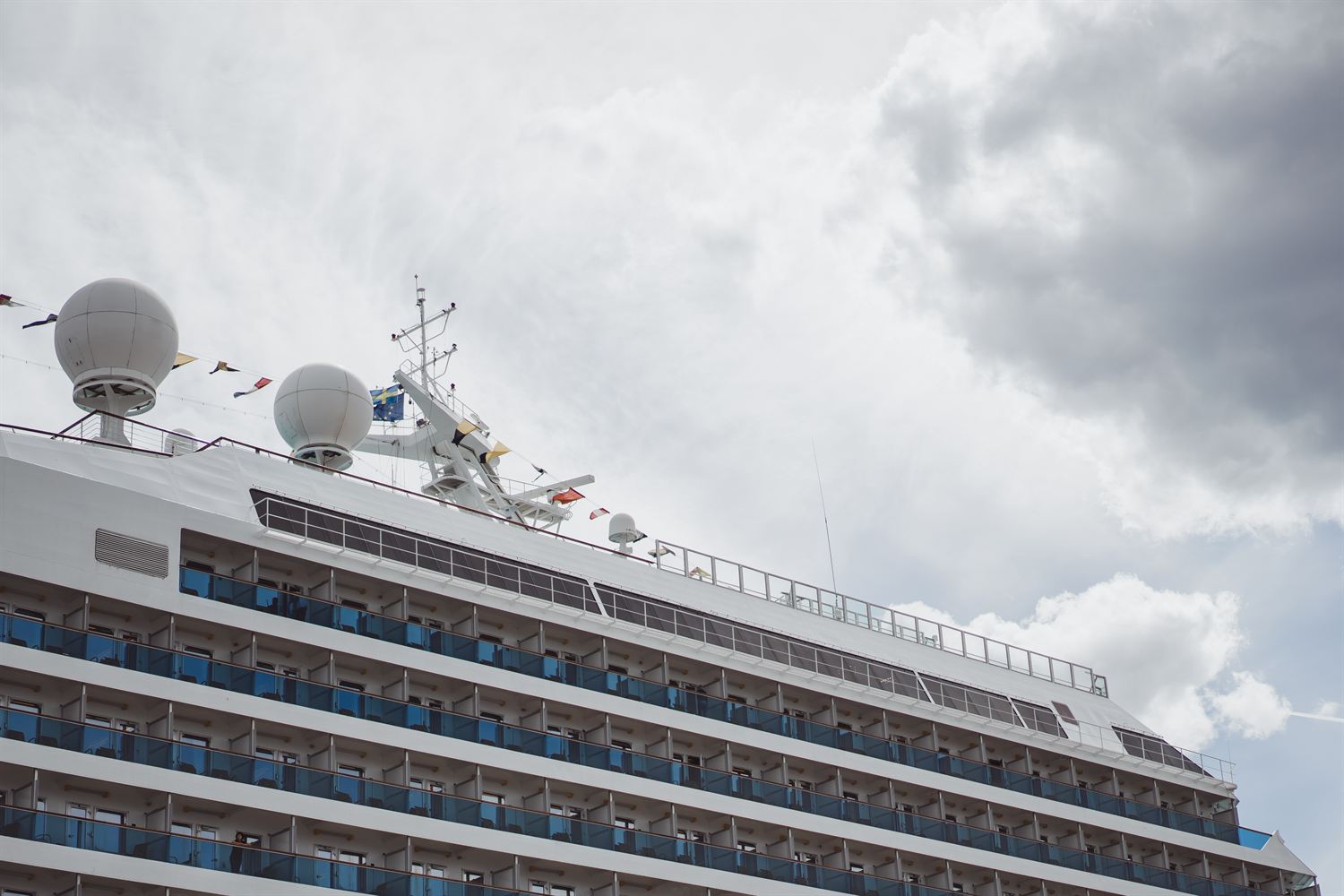 Side of a cruise ship under a cloudy sky