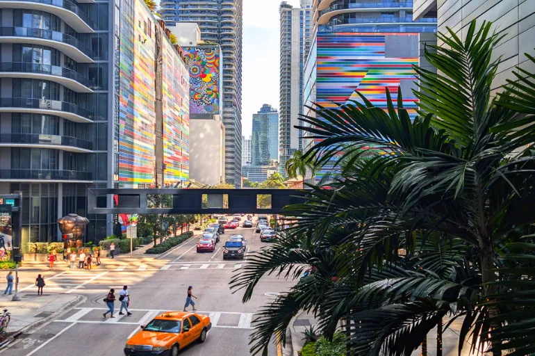 City street lined with high-rise buildings and palm trees