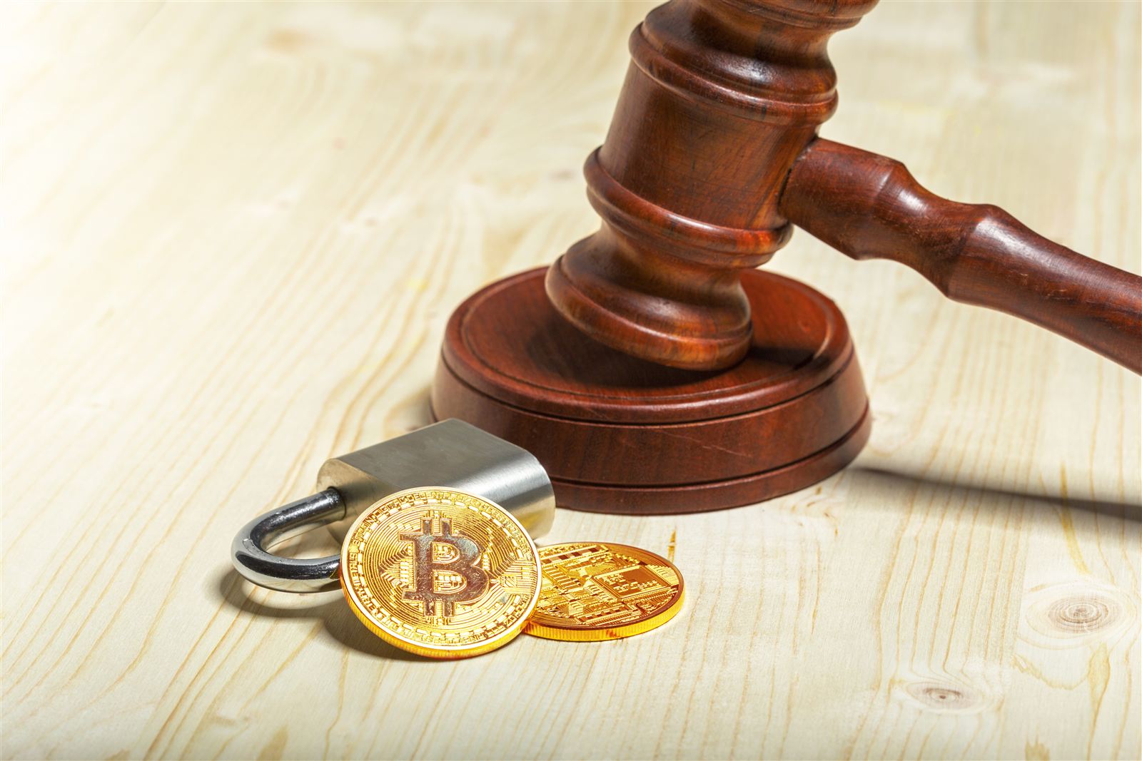 Gavel, padlock and cryptocurrency coins on a wooden table