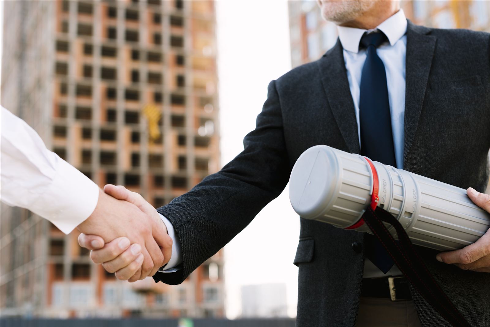 Handshake in front of a building under construction